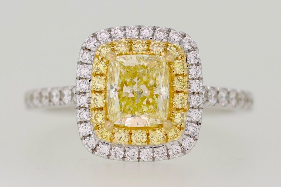 Anillo con diamante amarillo central, rodeada de diamantes en un diseño elegante.